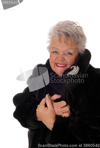 Image of Senior woman having fun with her fur coat.