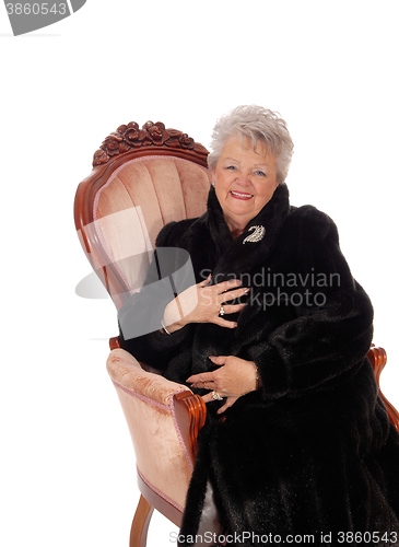 Image of Senior woman sitting in armchair.