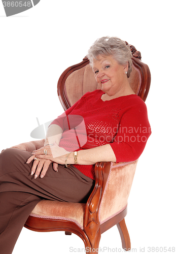 Image of Relaxed senior woman sitting in armchair.