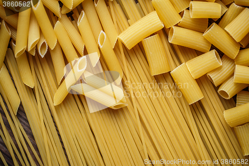 Image of close up portrait of raw homemade italian pasta, macaroni, spaghetti, and fettuccine