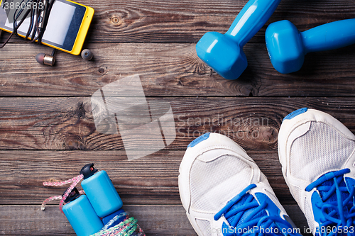 Image of Sports equipment - sneakers, skipping rope, dumbbells, smartphone and headphones. 