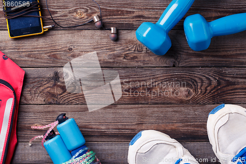 Image of Sports equipment - sneakers, skipping rope, dumbbells, smartphone and headphones. 