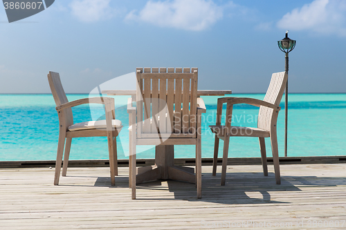 Image of outdoor restaurant terrace with furniture over sea