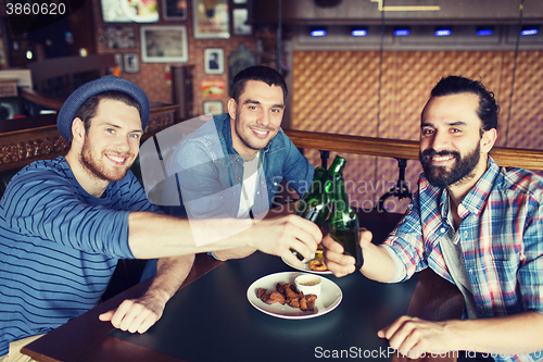 Image of happy male friends drinking beer at bar or pub