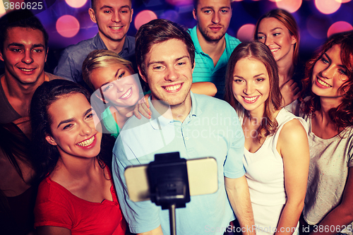 Image of friends with smartphone taking selfie in club