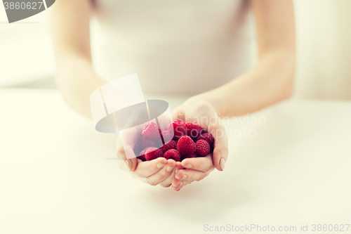 Image of close up of woman hands holding raspberries