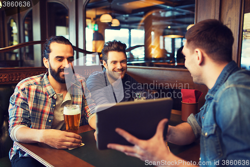 Image of male friends with tablet pc drinking beer at bar