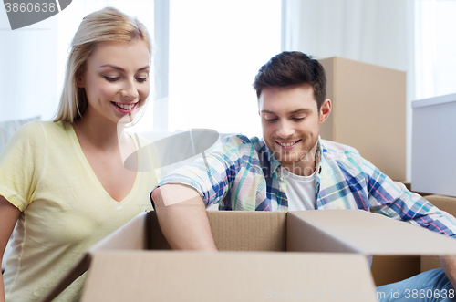 Image of smiling couple with big boxes moving to new home