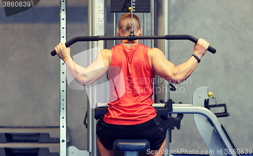 Image of man flexing muscles on cable machine gym