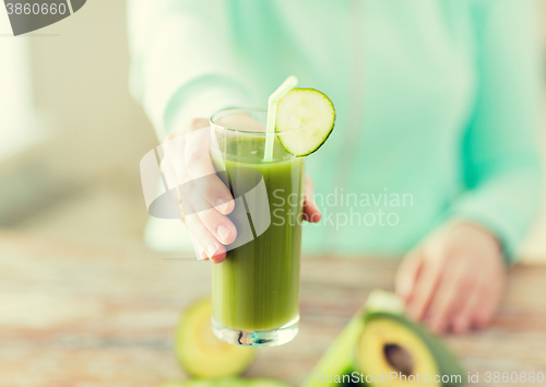 Image of close up of woman hands with juice and vegetables