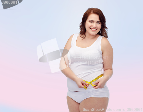 Image of happy young plus size woman with measuring tape