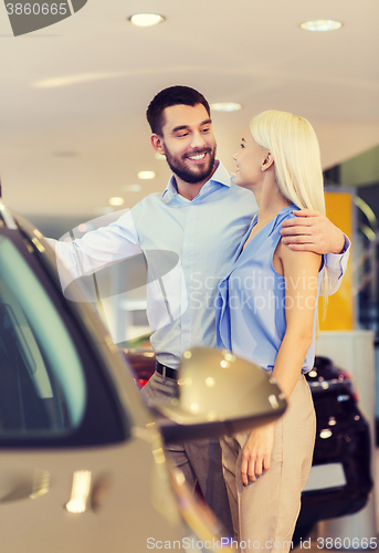 Image of happy couple buying car in auto show or salon