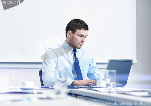 Image of businessman with laptop working in office