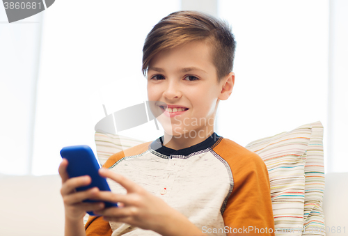Image of boy with smartphone texting or playing at home