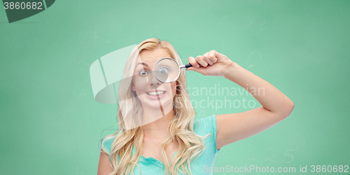 Image of happy young woman with magnifying glass