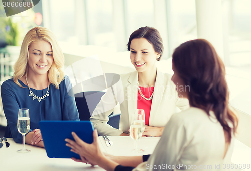 Image of happy women with tablet pc at restaurant