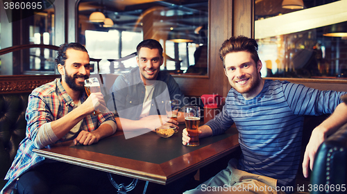 Image of happy male friends drinking beer at bar or pub