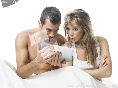Image of attractive couple watching things in a tablet