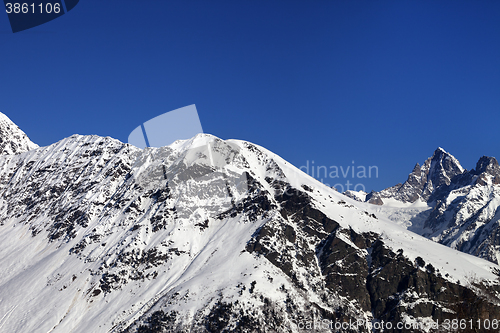 Image of Snowy mountains and blue clear sky at nice sun day