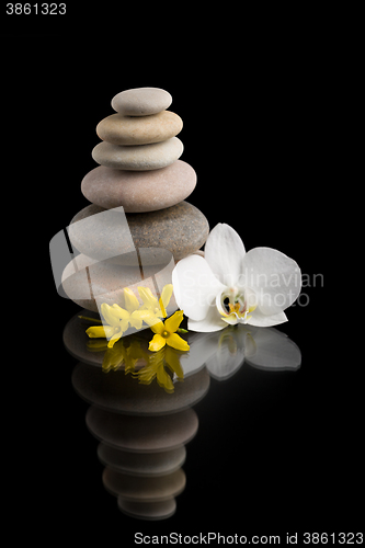 Image of balancing zen stones on black with white flower