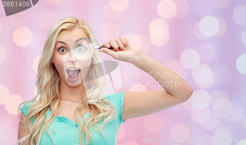 Image of happy young woman with magnifying glass