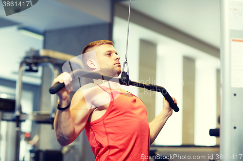 Image of man flexing muscles on cable machine gym