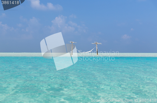 Image of hammock in water on maldives beach