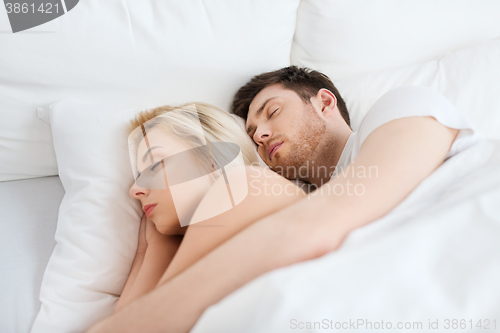 Image of happy couple sleeping in bed at home