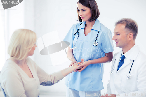 Image of nurse with patient measuring pulse