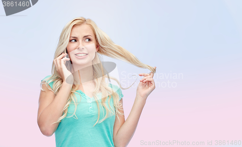 Image of smiling young woman calling on smartphone