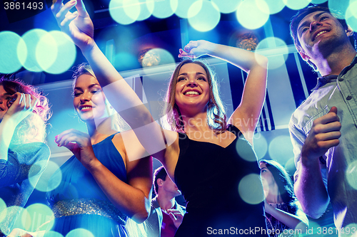 Image of smiling friends dancing in club