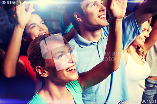 Image of smiling friends at concert in club