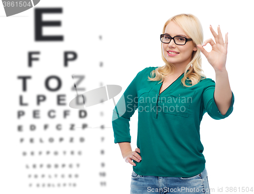 Image of smiling young woman with eyeglasses showing ok