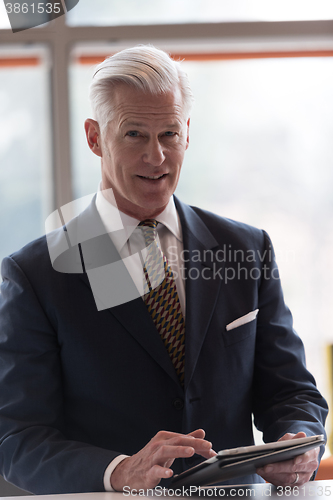 Image of senior business man working on tablet computer