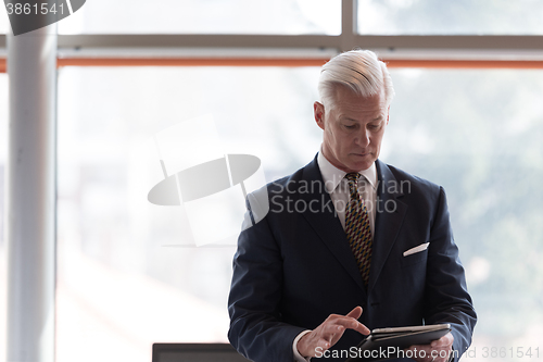 Image of senior business man working on tablet computer