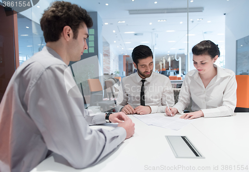 Image of young couple signing contract documents on partners back