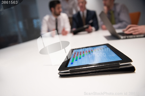 Image of close up of touchpad with analytics documents at business meetin