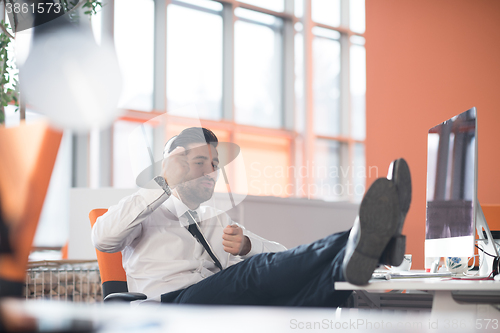 Image of relaxed young business man at office