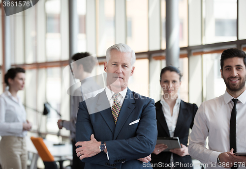 Image of portrait of senior businessman as leader  with group of people i