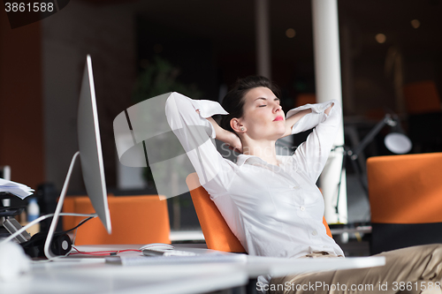 Image of happy young business woman relaxing and geting insiration