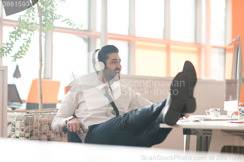 Image of relaxed young business man at office