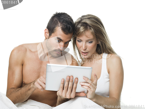 Image of attractive couple watching things in a tablet