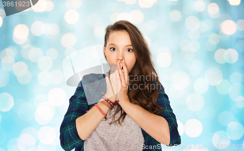 Image of scared teenage girl over blue holidays lights