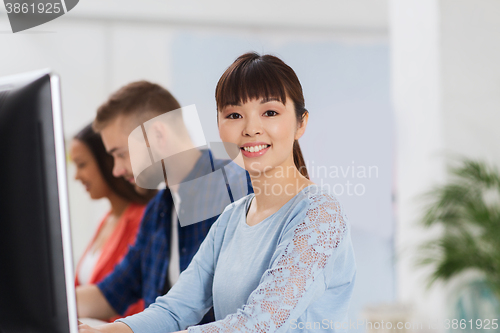 Image of happy creative team or students working at office