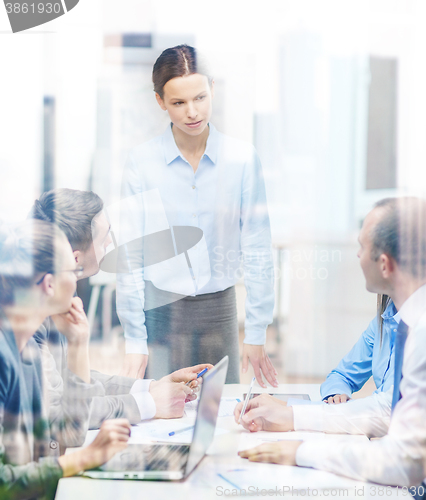 Image of strict female boss talking to business team