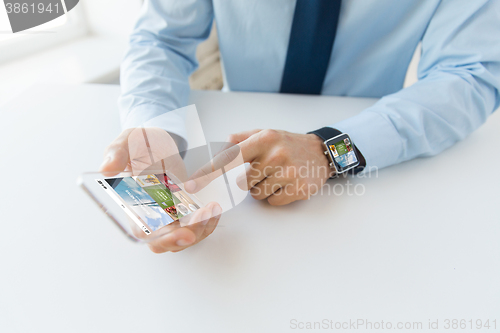 Image of close up of hands with smart phone and watch