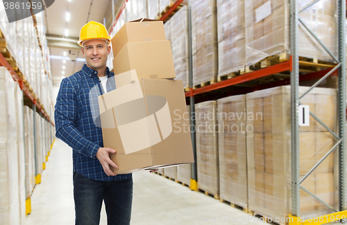 Image of happy man or loader with box at warehouse