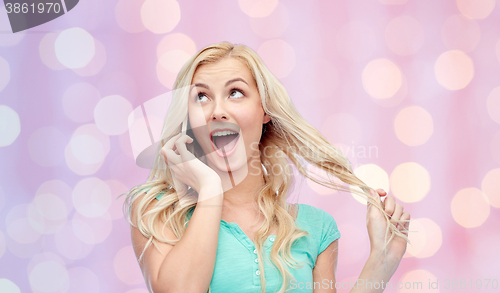 Image of smiling young woman calling on smartphone