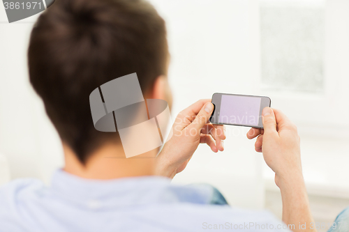 Image of close up of man with smartphone at home