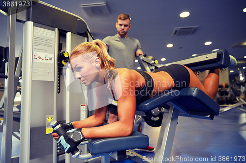 Image of man and woman flexing muscles on gym machine